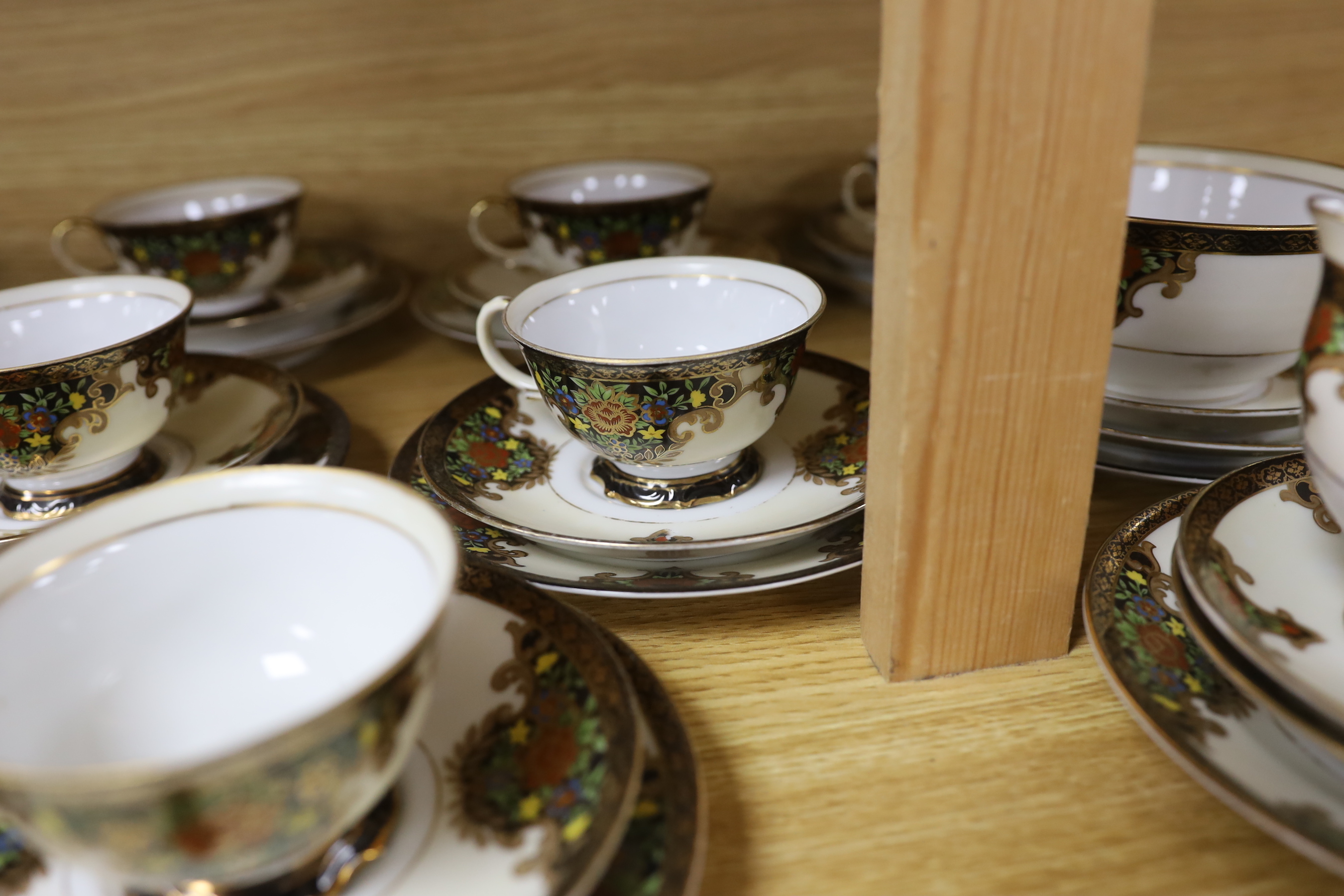A Japanese Noritake floral and gilt tea set, comprising a sugar bowl, a milk jug, nine cups, plus saucers and tea plates